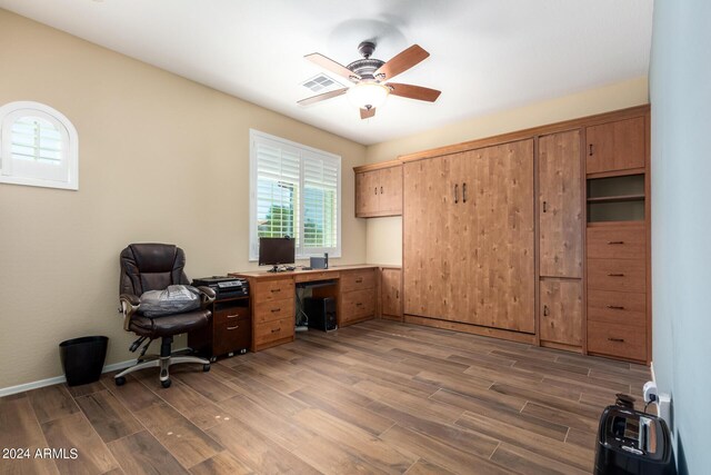 home office featuring baseboards, visible vents, ceiling fan, and wood finished floors