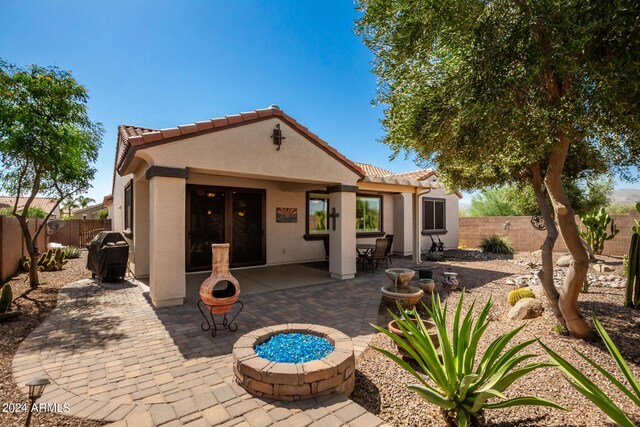 back of property featuring a fenced backyard, a tile roof, stucco siding, and a patio