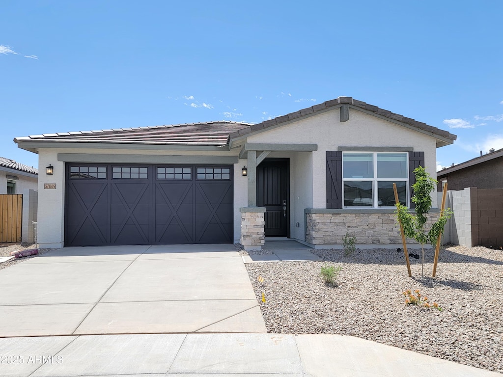 37069 W Prado St, Maricopa, AZ 85138 - view of front facade with fence, stucco siding, a tiled roof, concrete driveway, and an attached garage