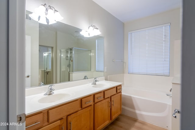 bathroom with independent shower and bath, vanity, and hardwood / wood-style flooring