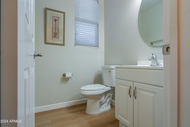 bathroom with hardwood / wood-style flooring, vanity, and toilet