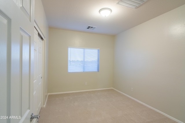 unfurnished bedroom featuring a closet and light colored carpet