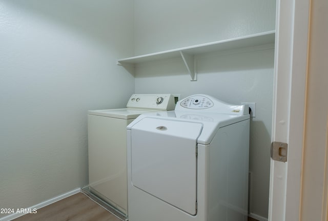 laundry area with light hardwood / wood-style floors and separate washer and dryer