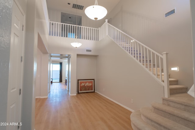 stairway featuring a high ceiling and hardwood / wood-style flooring