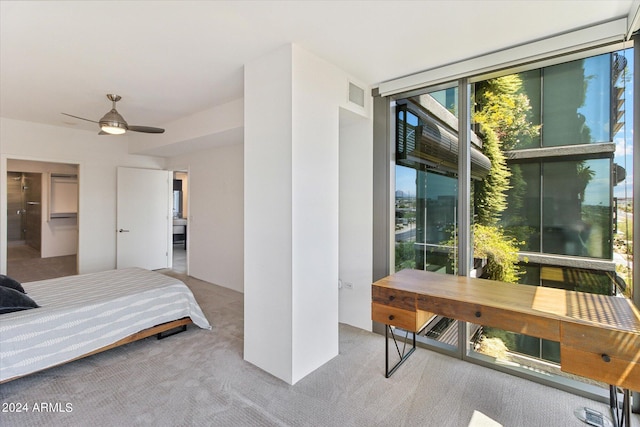 carpeted bedroom with expansive windows and ceiling fan