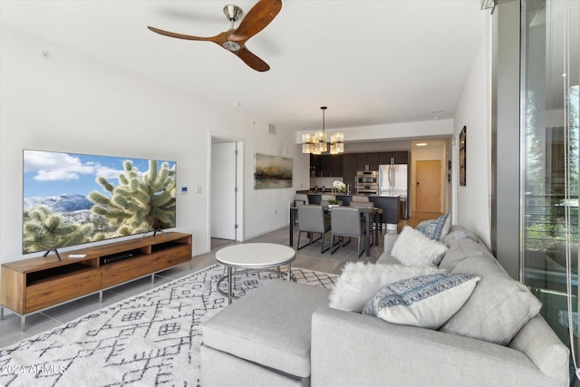 living room with light tile patterned flooring and ceiling fan with notable chandelier