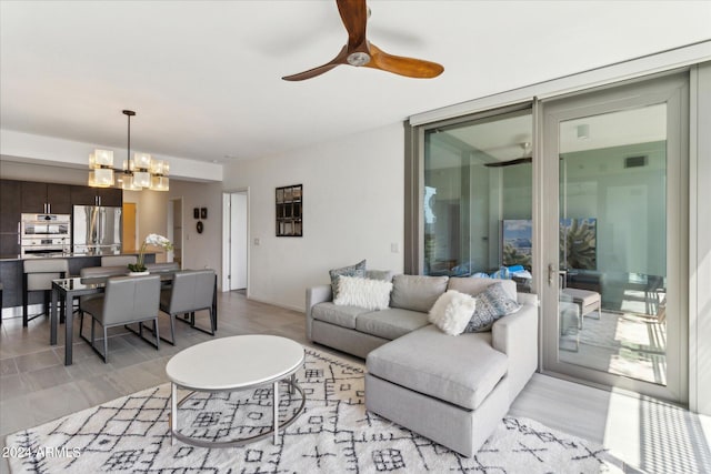 living room with expansive windows and ceiling fan with notable chandelier