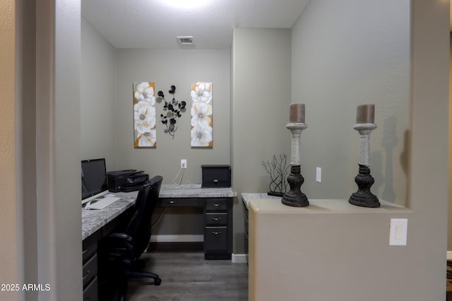 office area with dark hardwood / wood-style floors and built in desk