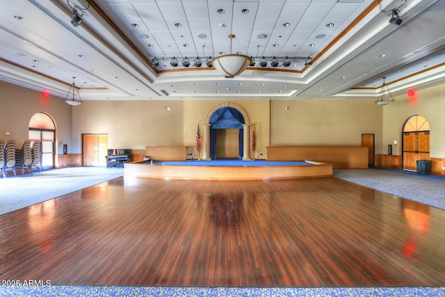 interior space with a towering ceiling, carpet flooring, and a raised ceiling