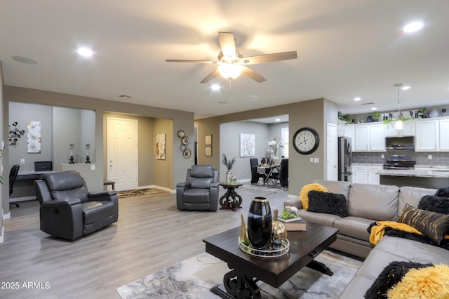 living room featuring ceiling fan and light wood-type flooring