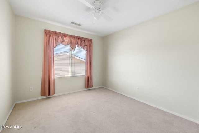 unfurnished room with visible vents, baseboards, light colored carpet, and a ceiling fan