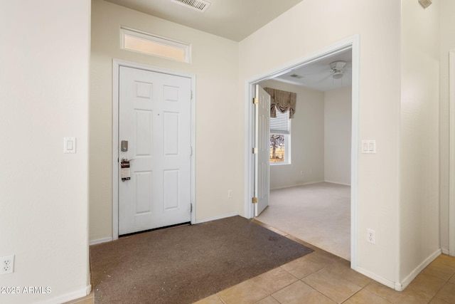 tiled foyer entrance featuring visible vents, baseboards, and carpet