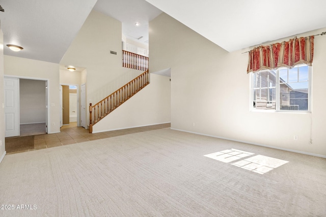 unfurnished living room featuring baseboards, stairway, carpet flooring, a towering ceiling, and tile patterned floors