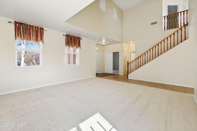 unfurnished living room featuring stairway, visible vents, and carpet floors