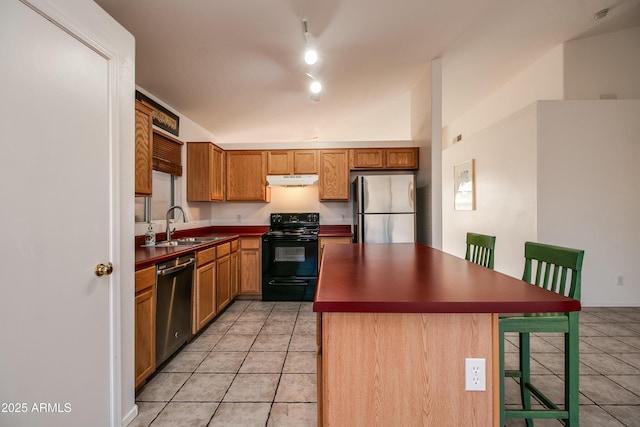 kitchen featuring light tile patterned flooring, appliances with stainless steel finishes, sink, and a center island