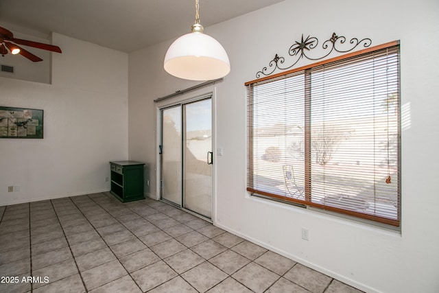 tiled spare room featuring a healthy amount of sunlight and ceiling fan