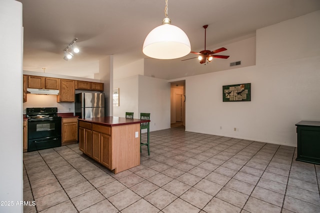 kitchen featuring a kitchen island, a breakfast bar, stainless steel fridge, ceiling fan, and black range with electric cooktop