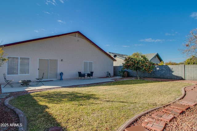 rear view of property featuring a patio area, a lawn, and an outdoor fire pit