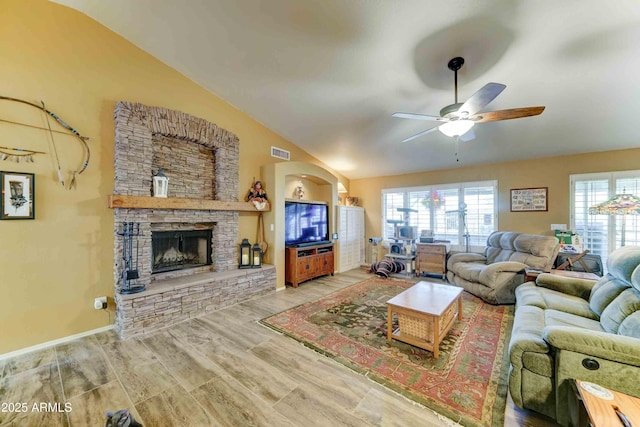 1704 S Barkley Rd, Apache Junction, AZ 85119 - living room with lofted ceiling, ceiling fan, wood finished floors, and a stone fireplace