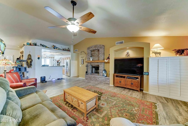 1704 S Barkley Rd, Apache Junction, AZ 85119 - living room with a ceiling fan, wood finished floors, vaulted ceiling, and a fireplace