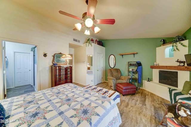 1704 S Barkley Rd, Apache Junction, AZ 85119 - bedroom with wood finished floors, a glass covered fireplace, and ceiling fan