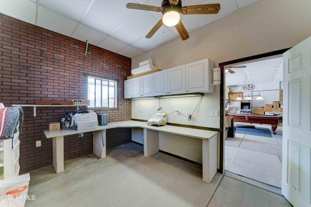 1704 S Barkley Rd, Apache Junction, AZ 85119 - unfurnished office featuring brick wall, a ceiling fan, a paneled ceiling, and concrete flooring