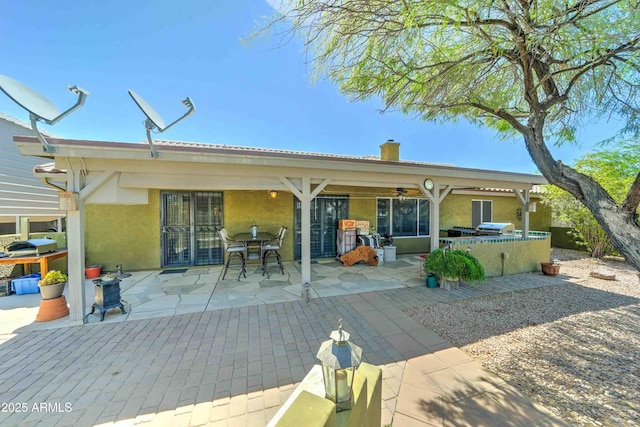 1704 S Barkley Rd, Apache Junction, AZ 85119 - back of house with stucco siding, a patio area, area for grilling, a chimney, and ceiling fan