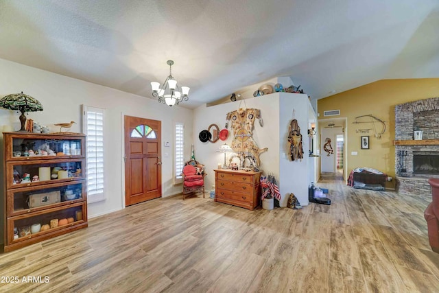 1704 S Barkley Rd, Apache Junction, AZ 85119 - entrance foyer featuring a chandelier, wood finished floors, vaulted ceiling, and a fireplace