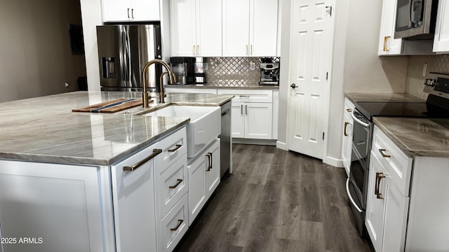 kitchen featuring appliances with stainless steel finishes, sink, a center island with sink, and white cabinets