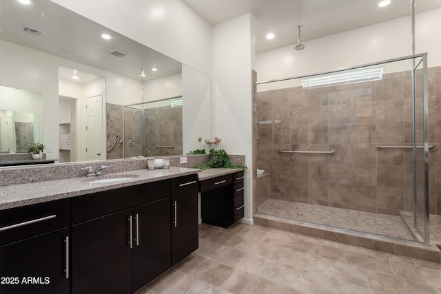 bathroom featuring visible vents, a stall shower, and vanity