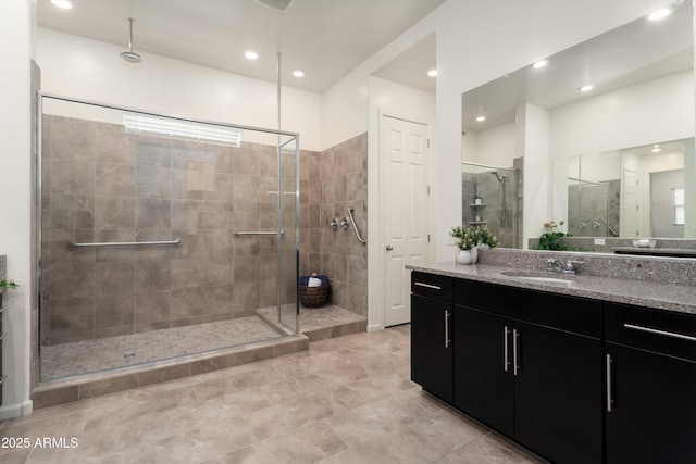 bathroom with recessed lighting, a shower stall, and vanity