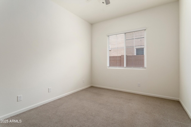 spare room featuring light colored carpet, baseboards, and ceiling fan