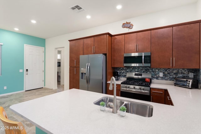 kitchen featuring visible vents, a toaster, a sink, stainless steel appliances, and light countertops