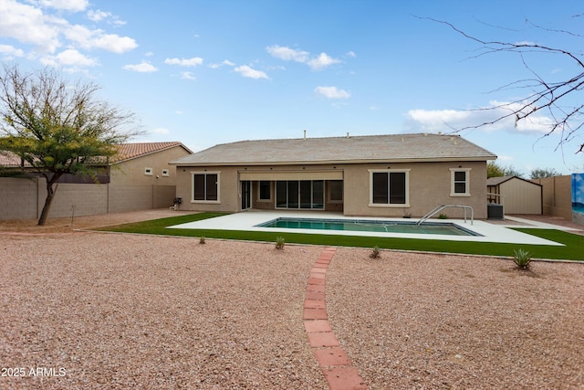 rear view of house featuring a patio area, a shed, stucco siding, and a fenced backyard