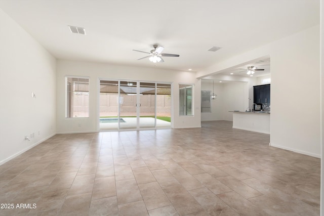 empty room featuring baseboards, visible vents, and ceiling fan