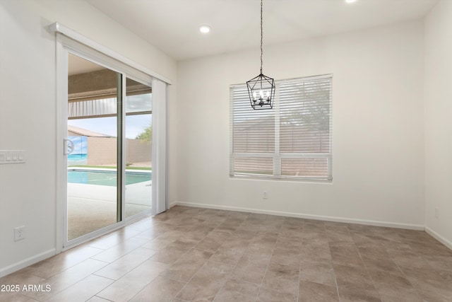 empty room featuring a notable chandelier, recessed lighting, and baseboards