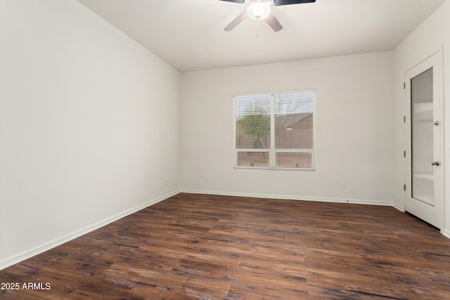 spare room with baseboards, a ceiling fan, and dark wood-style flooring