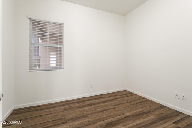 unfurnished room featuring dark wood-style floors and baseboards