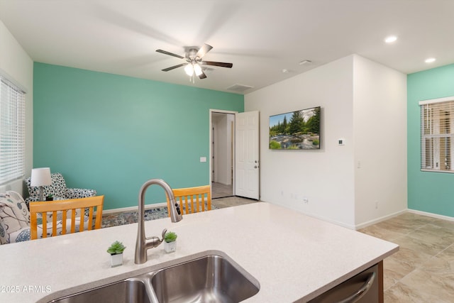 kitchen featuring a sink, recessed lighting, light countertops, baseboards, and ceiling fan