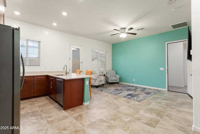 kitchen with visible vents, a peninsula, a sink, stainless steel appliances, and open floor plan