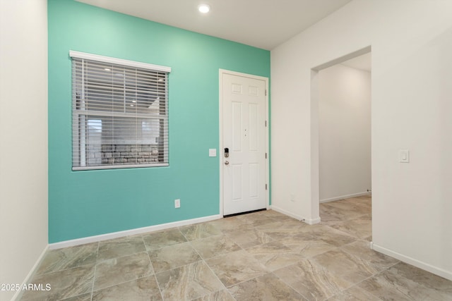 spare room featuring recessed lighting and baseboards