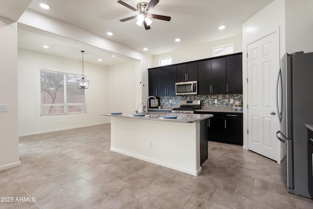 kitchen with dark cabinetry, ceiling fan, decorative backsplash, stainless steel appliances, and pendant lighting