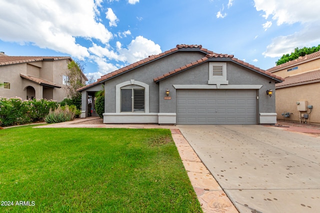 mediterranean / spanish home featuring a front yard and a garage