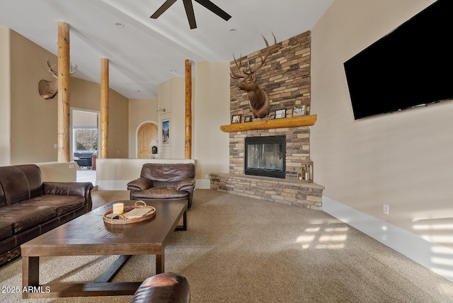 living room with ceiling fan, carpet, a towering ceiling, and a fireplace