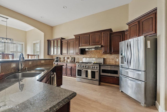 kitchen featuring dark brown cabinetry, sink, decorative light fixtures, and appliances with stainless steel finishes