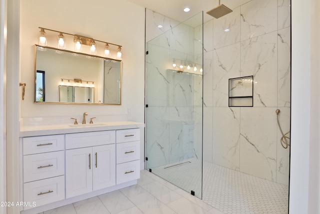 bathroom with a tile shower and vanity