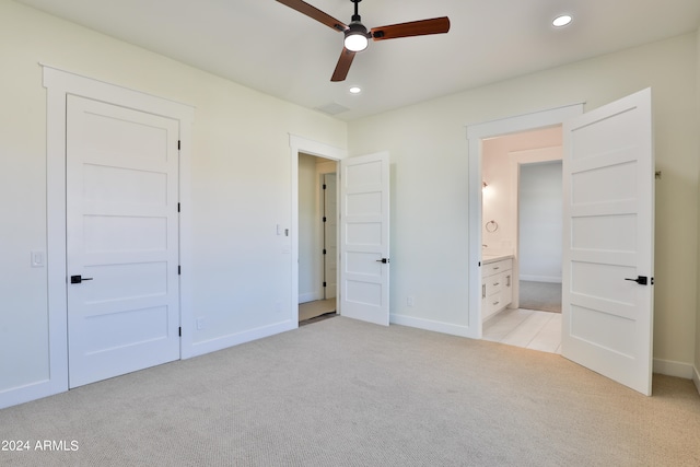 unfurnished bedroom with connected bathroom, light carpet, and ceiling fan