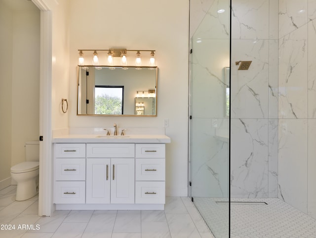 bathroom with toilet, vanity, and tiled shower