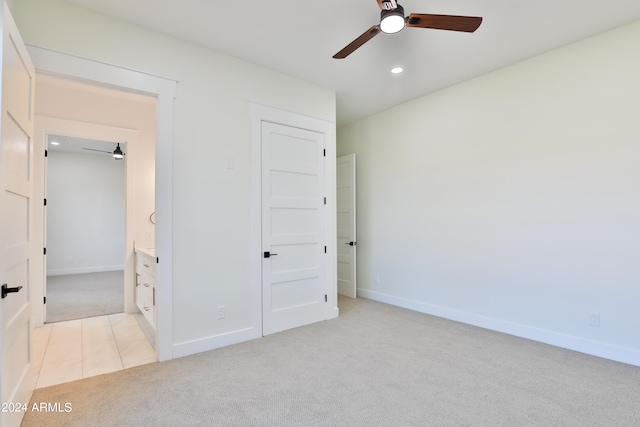 unfurnished bedroom with connected bathroom, light carpet, and ceiling fan