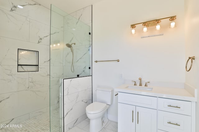 bathroom featuring vanity, a tile shower, and toilet